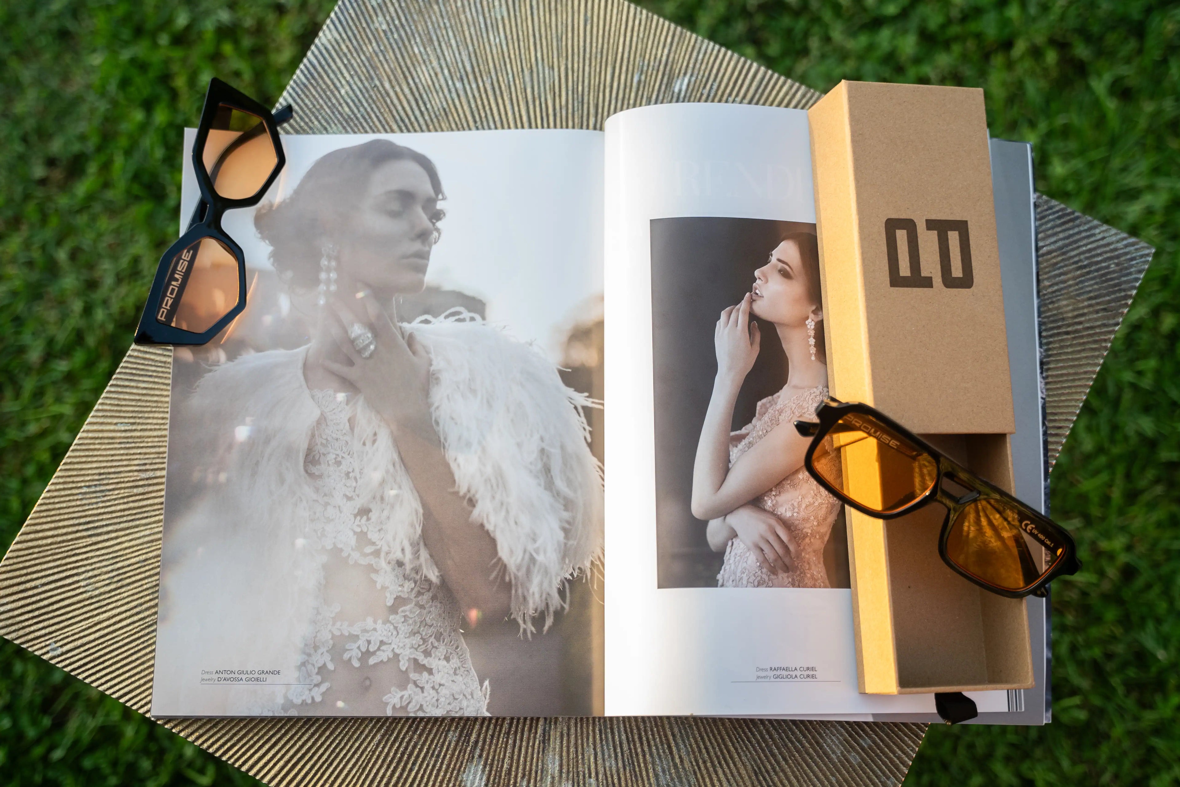 Occhiali da sole PROMISE su rivista di moda con box e custodia, stile elegante al tramonto.